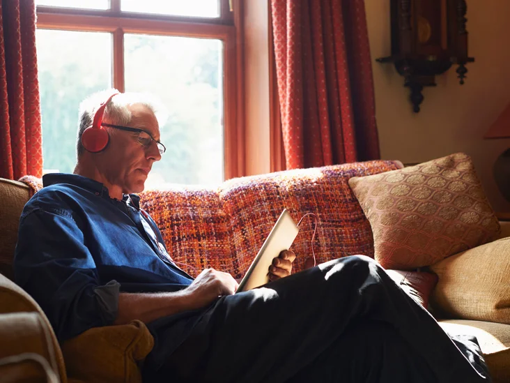 elderly man reading on iPad
